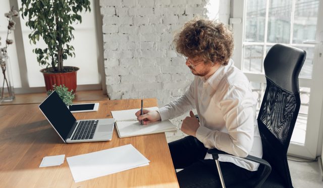 Caucasian young man in business attire working in office, job, online studying
