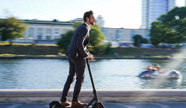 Young,Business,Man,In,A,Suit,Riding,An,Electric,Scooter